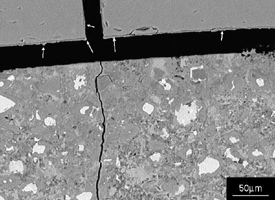 Image showing residual alkali silicate gel adhering to the glass surfaces (arrowed).