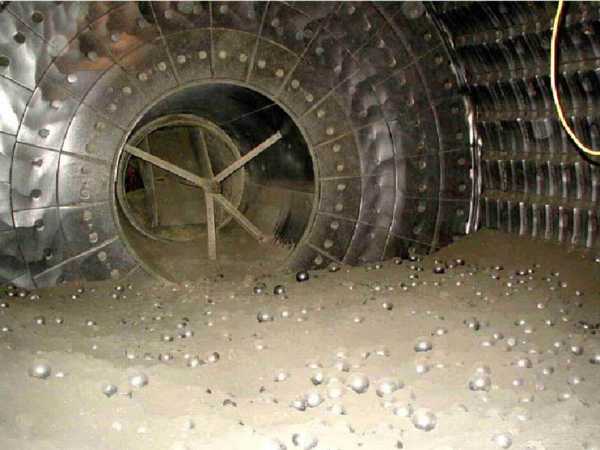 View inside a (stationary!) cement mill. The part-ground clinker and steel grinding media are clearly visible. (Picture courtesy Castle Cement).